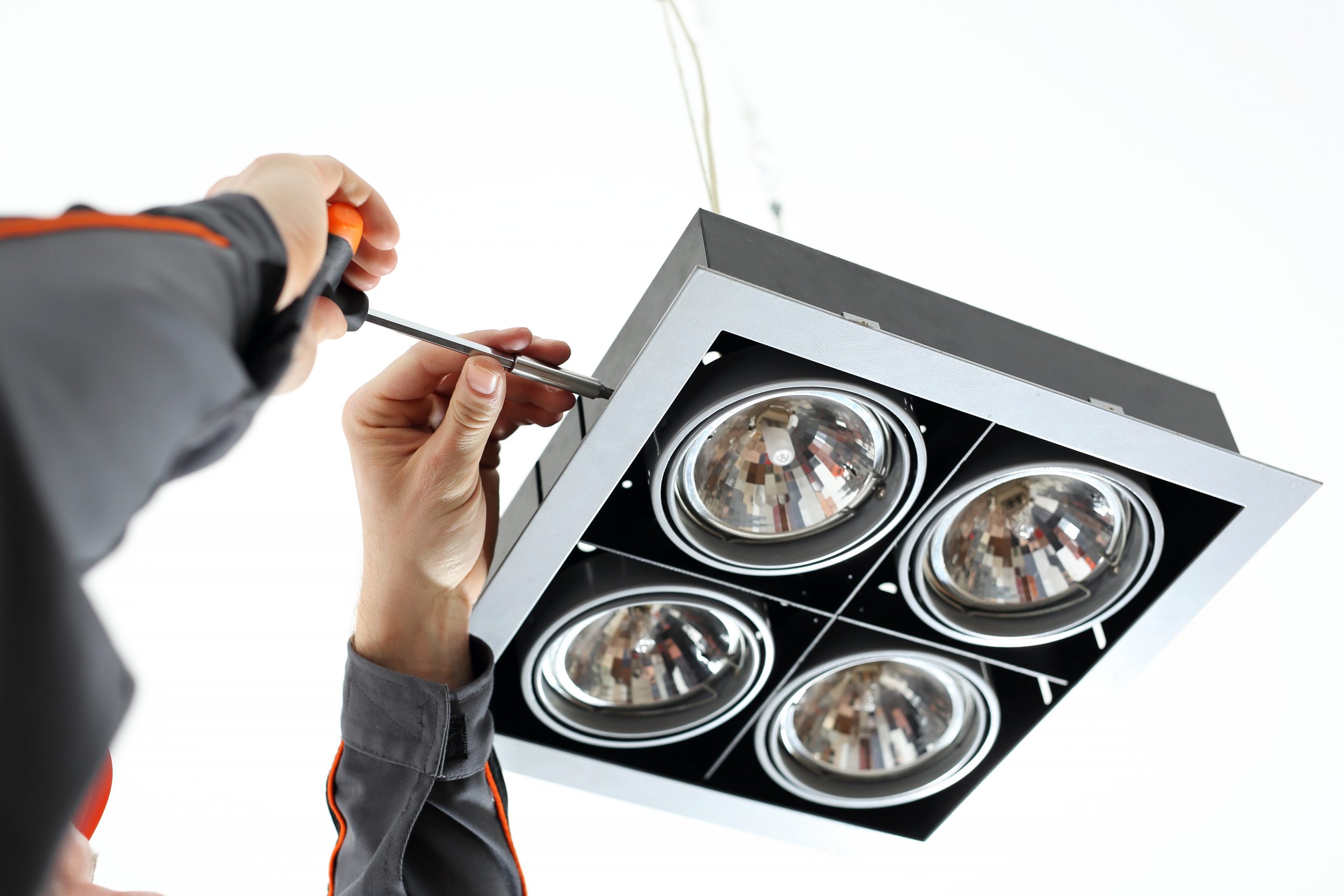 Elektryk. Elektryk naprawia lampę sufitową.